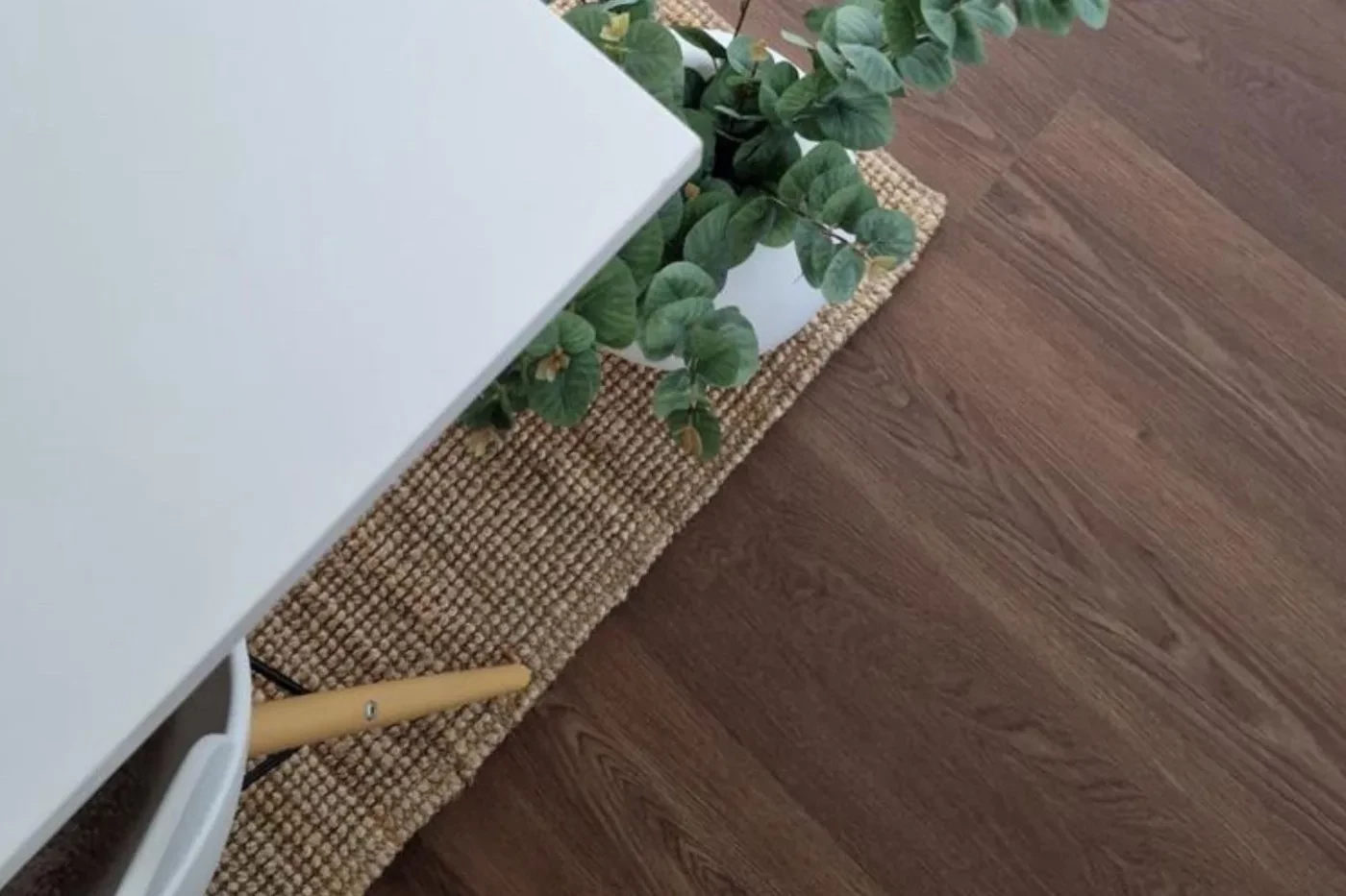 Juuttimatto tummalla vinyylilattialla ruokapöydän alla