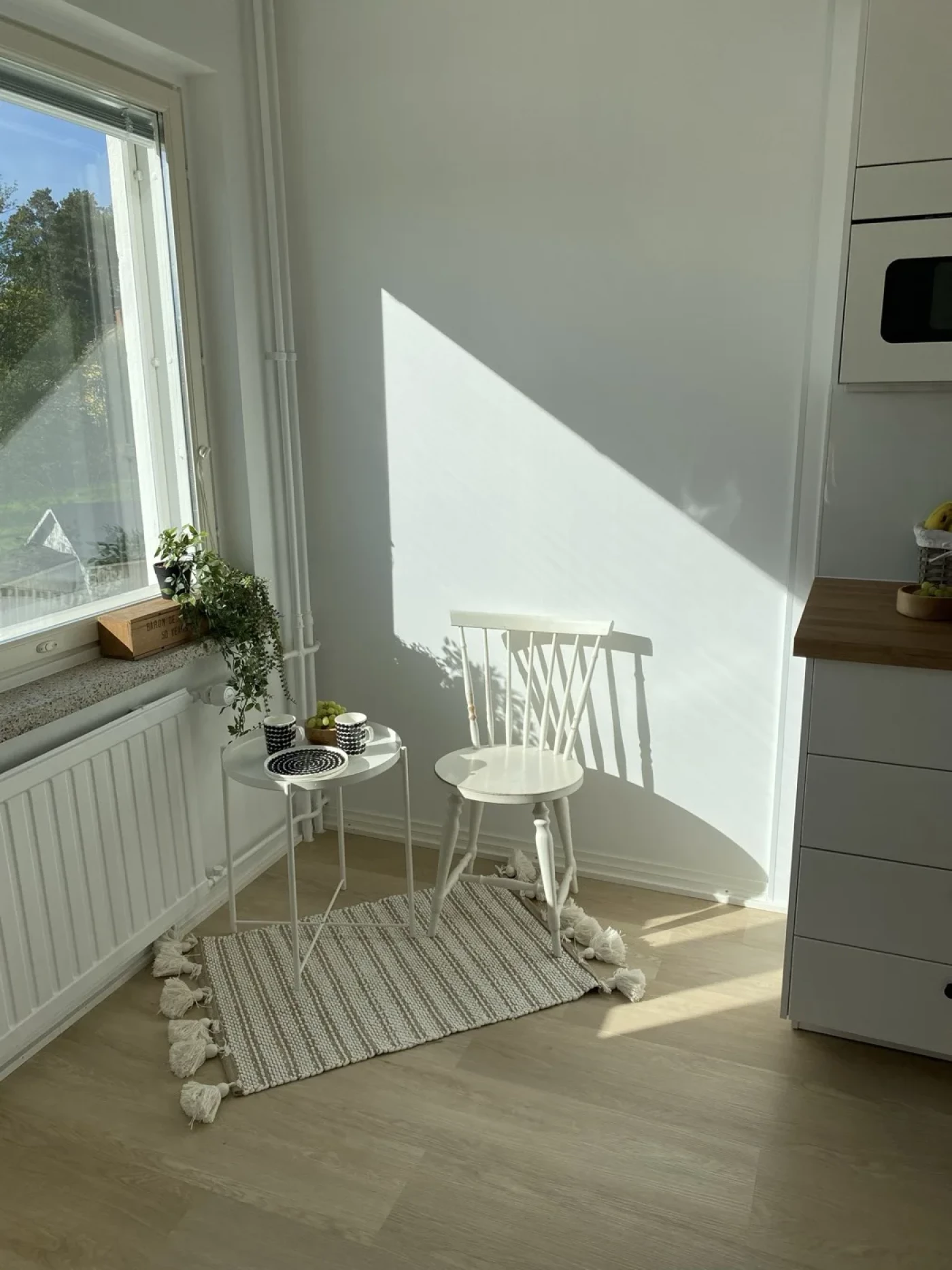 Valoisa nurkkaus, jossa raidallinen matto vaalealla vinyylilattialla
